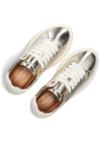 Zilveren metallic sneakers met witte veters, ronde neus, gemaakt van leer en textiel, met een bruine binnenvoering en logo-detail.