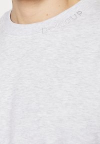 Jasnoszara bluza z okrągłym dekoltem, wykonana z miękkiego materiału. Posiada subtelne haftowane napisy "DON DUP" w pobliżu kołnierza.