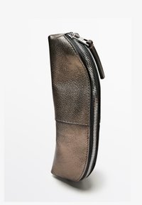 Trousse à crayons en cuir texturé de couleur bronze métallique, de forme incurvée, avec une fermeture éclair noire et une surface lisse et brillante.