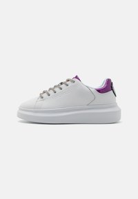 Witte lage sneaker met dikke zool, zilveren veters, paarse stofaccenten en geperst "Just Cavalli" logo op de zijkant.