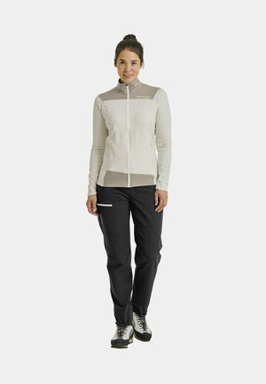 Light-colored zip-up jacket with beige accents, paired with black pants featuring pockets. Textured fabric with a fitted design.