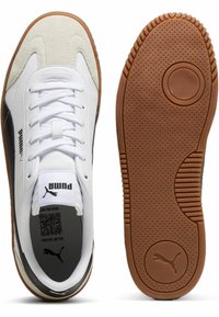 Hvide sneakers med sorte og grå accenter, suedesnude, perforeret sort indvendig, og gummisål med tekstureret mønster.