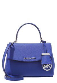 Sac à main synthétique bleu avec une poignée supérieure et une bandoulière amovible. Présente des accessoires en métal argenté et un accent de logo de la marque sur un pendentif.