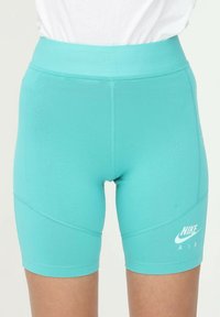 Tyrkysové sportovní šortky s přiléhavým designem. Mezi vlastnosti patří texturovaný pas a bílé logo Nike Air na dolním pravém rohu.