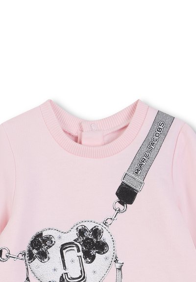 Różowa bluza z nadrukiem przedstawiającym torbę w kształcie serca z kwiatowymi akcentami, metalicznymi detalami i czarnym paskiem z napisem "MARC JACOBS."