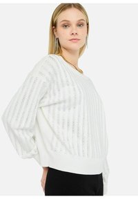 Maglione bianco lavorato a maglia con strisce verticali e motivo testurizzato, vestibilità ampia e polsini a coste. Presenta un collo a V.
