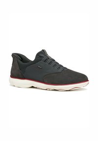Zapatillas grises con un diseño de materiales mixtos en ante y malla, forma redondeada, acentos rojos y una suela blanca acolchada.