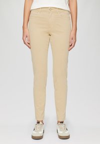 Beżowe spodnie slim-fit z mieszanki bawełny, z klasycznym pięciokomorowym wzornictwem, przeszyciami i zapięciem na guzik w talii.