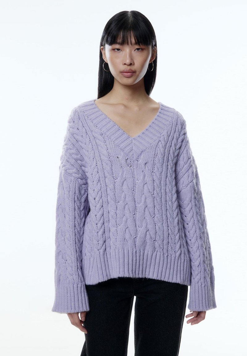 Lila Kabelstrickpullover mit V-Ausschnitt und langen, weiten Ärmeln. Verfügt über einen ribbeligen Saum und ein strukturiertes Muster über das gesamte Kleidungsstück.