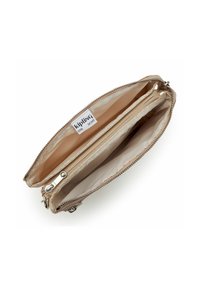 Beige Kipling plånbok öppen, som visar tre fack inklusive en centralt placerad zip-fack och en tygetikett inuti.