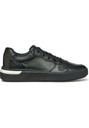 Baskets en cuir noir avec un bout rond, surface texturée, six œillets et une semelle en caoutchouc avec un accent blanc le long du bord.