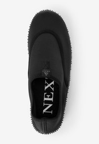 Schwarzer Slipper aus weichem Material mit texturiertem Profil und elastischen Seiten. Verfügt über ein kleines Logo-Tag und ein gepolstertes Innenfutter.
