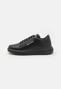Black leather sneaker with a smooth finish, lace-up design, round toe, padded collar, and a thick sole featuring a logo at the heel.