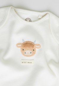 Bílé dětské body s vyšitým hnědým obličejem krávy a textem "mini moo" pod motivem na hrudníku.