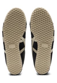 Černé semišové tenisky s béžovými akcenty, které mají texturovanou pryžovou podrážku s trojúhelníkovým vzorem a detaily značky na patě.