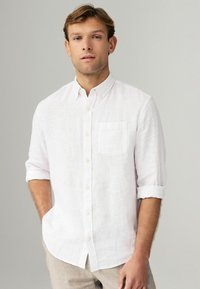 Weißes Leinenhemd mit Button-down-Kragen, Brusttasche und hochgekrempelten Ärmeln. Subtile Textur im gesamten Hemd. Angenehmer, lässiger Schnitt.