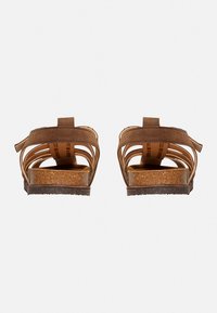 Braune Wildledersandalen mit offenem Design, ausgestattet mit mehreren Riemen und einer strukturierten Korkfußbett. Robuste Gummisohle für Langlebigkeit.