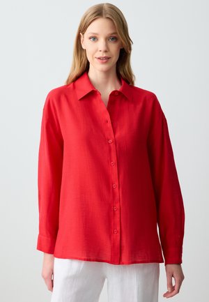 Rotes, langärmliges Hemd mit Kragen und durchgehendem Knopfverschluss aus leichtem Stoff. Mit lockerer Passform und aufgerollten Bündchen.