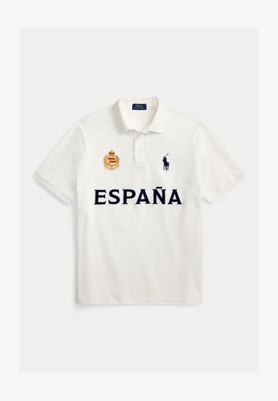 Λευκό πόλο με το κείμενο "ESPAÑA", κεντημένο ισπανικό έμβλημα στο αριστερό στήθος και μαύρο λογότυπο Polo Ralph Lauren με άλογο στο δεξί στήθος.