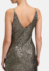 Robe pailletée avec un dos en V, ornée de sequins argentés et dorés scintillants, dotée de fines bretelles et d'une fermeture éclair au dos.