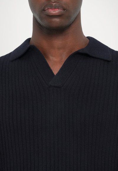 Navy ribbed knit polo with a V-neckline and short collar, featuring a textured fabric and a close-fit design.