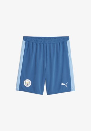 Shorts de sport bleus avec des bandes latérales bleu clair, écusson de Manchester City sur la jambe gauche et logo blanc Puma sur la jambe droite.