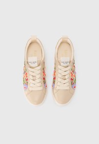 Beige sneakers med blomsterbroderi i rosa, rødt og lilla på sidene. Har rund tå, flate snørebånd og merkede tunge etiketter.