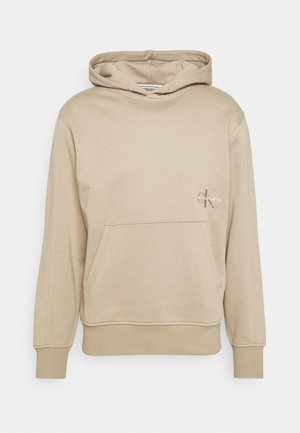 Beigefarbenes Hoodie mit Fronttasche und Calvin Klein Jeans Logo auf der linken Brust, mit gerippten Bündchen und Saum.