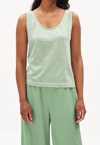 Débardeur rayé vert avec un encolure dégagée, fabriqué en tissu doux ; associé à un pantalon large vert. Les deux ont une texture lisse.