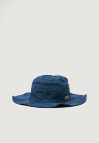 Blå denim bøttehatt med bred skygge, med en teksturert overflate og små runde metalldetaljer. Inkluderer et logomerke på siden.