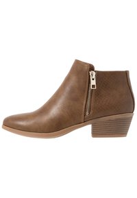 Bottine synthétique marron à bout pointu, fermeture éclair latérale et accents texturés. Dotée d'un talon empilé et d'une finition lisse.