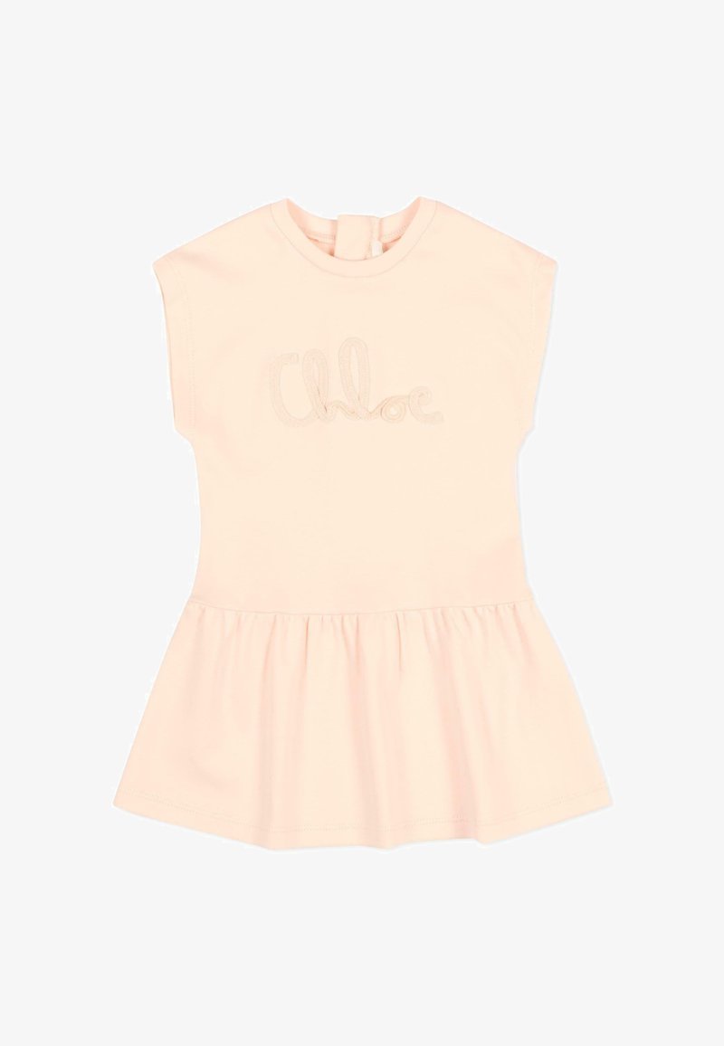 Robe sans manches pour tout-petit de couleur pêche claire, avec jupe froncée et texte "Chloé" brodé sur la poitrine.