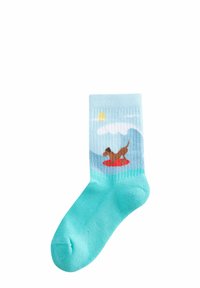 Cotton sock featuring a light blue upper with a graphic of a dog on a red float, surrounded by waves, clouds, and a yellow sun against a blue sky.
