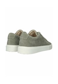 Een paar lage sneakers van grijs suède met witte rubberen zolen, gezien vanaf de achterkant en zijkant op een witte achtergrond.