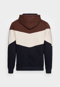 Sudadera con capucha de tres secciones en bloque de color: marrón, crema y marino. Tejido suave, corte regular, puños y dobladillo acanalados.