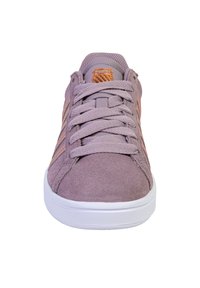 Lila mockaskor med en texturerad yta, utrustade med platta snören, en vit gummisula och subtila orange randiga detaljer på sidorna.