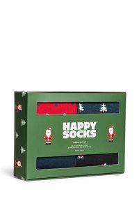 Gavegaveæske med fire par strømper: rød med hvide prikker, marineblå med træer, mørkegrå og sort. Æsken har et grønt og hvidt design.