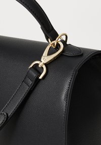 Borsa a tracolla in pelle nera texture con chiusura e attacco della tracolla in tonalità oro, dotata di un top curvo e una forma semi-strutturata liscia.