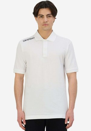Polo bianco in cotone con maniche corte, colletto e due bottoni. Presenta il logo nero "Kappa" sulla spalla sinistra. Design semplice.