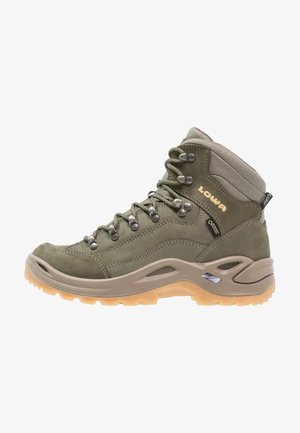 Botte de randonnée haute verte avec semelle beige, œillets métalliques et étiquette Gore-Tex, avec le logo "Lowa" sur le côté.