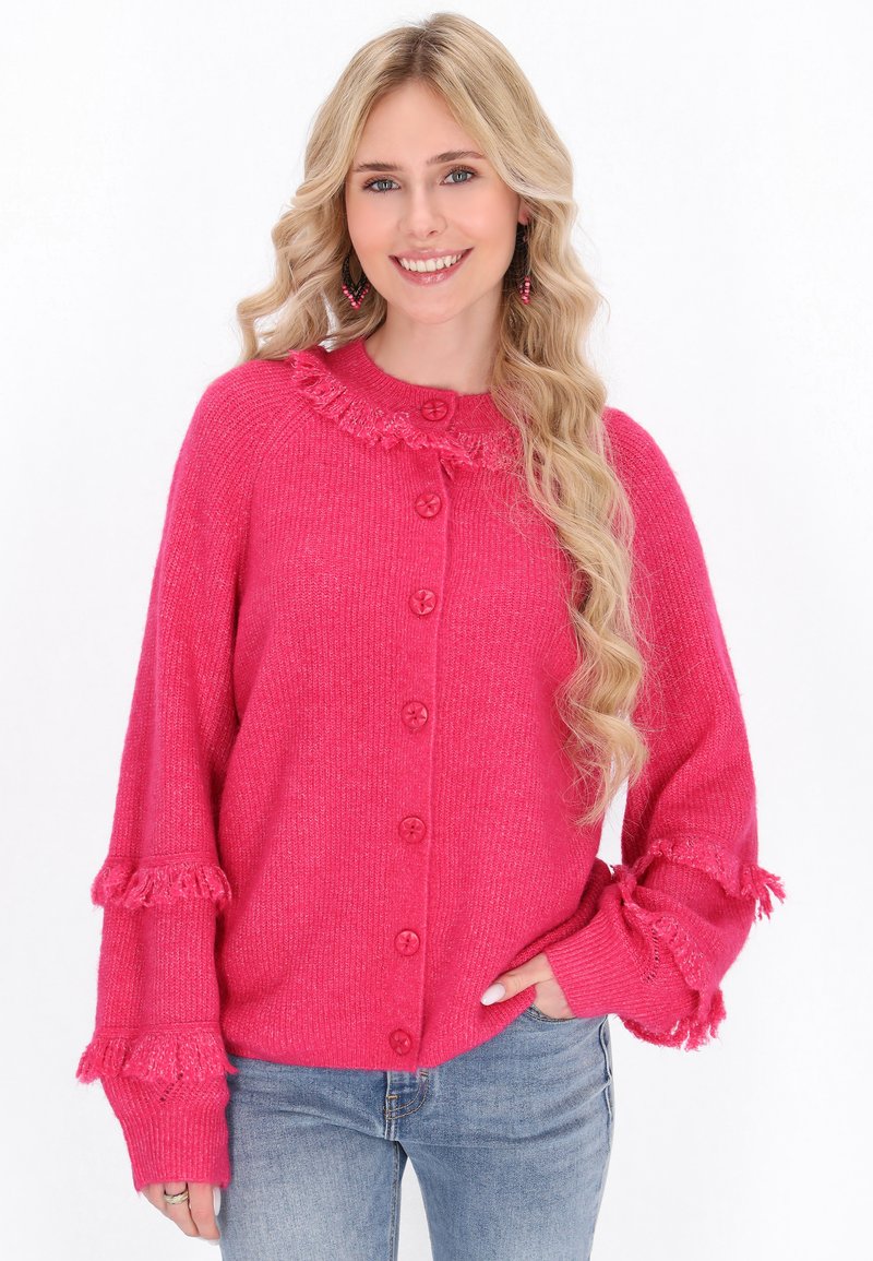 Cardigan rosa lavorato a maglia con scollo rotondo, chiusura anteriore con bottoni e dettagli a frange sulle maniche. Tessuto texture con una vestibilità comoda.