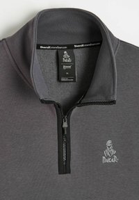 Szary rozpinany sweter z prążkowanym kołnierzem, z czarnym zamkiem błyskawicznym i logo na piersi. Materiał wydaje się miękki i teksturowany. Rozmiar XL.