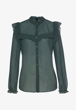 Doorzichtige donkergroene blouse met lange mouwen en witte polkadots, geplooide kraag, schouder- en manchetdetails en knoopsluiting aan de voorkant.