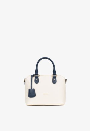 Petit sac à main en matériau crème texturé avec des accents bleu marine. Il présente deux poignées supérieures, des accessoires en or et une étiquette de porte-clés.