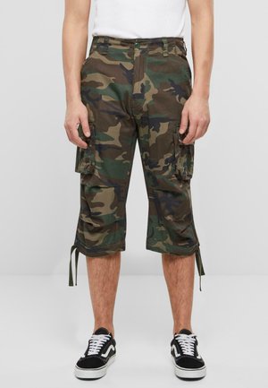 Camouflage cargo shorts van katoen met een knielange snit, zijzakken en trekkoorddetails aan de zoom. Gecombineerd met zwarte sneakers.