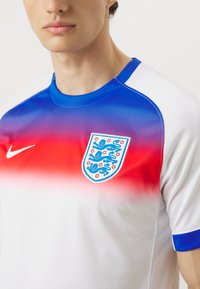 Maglietta Nike a maniche corte con una sfumatura che va dal rosso al blu, con una base bianca e il simbolo dell'Inghilterra sul petto. Tessuto liscio e traspirante.