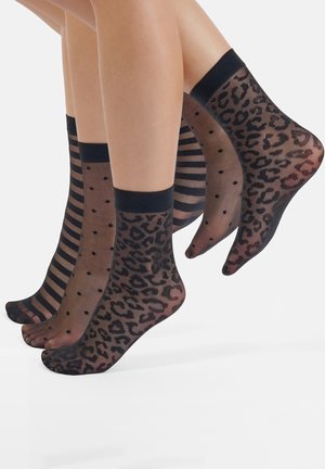 Black ankle socks featuring three designs: one with horizontal stripes, one with polka dots, and one with a leopard print.