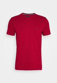 T-shirt rossa a maniche corte con scollatura rotonda, caratterizzata da un leggero motivo testurizzato e un piccolo logo sul lato sinistro del petto.