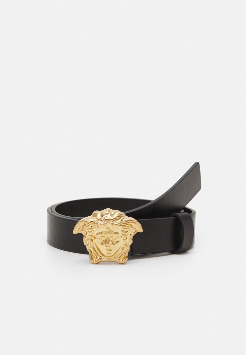 Zwarte leren riem met een goudkleurige Medusa-hoofddraad. De band is glad en heeft een elegante, minimalistische uitstraling zonder zichtbare patronen.