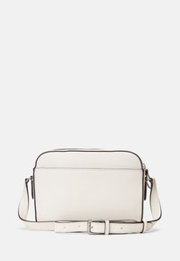 Vit läder crossbody-väska med en jämn yta, kontrasterande bruna detaljer, dragkedjestängning och justerbar rem. Subtil logotyp framtill.